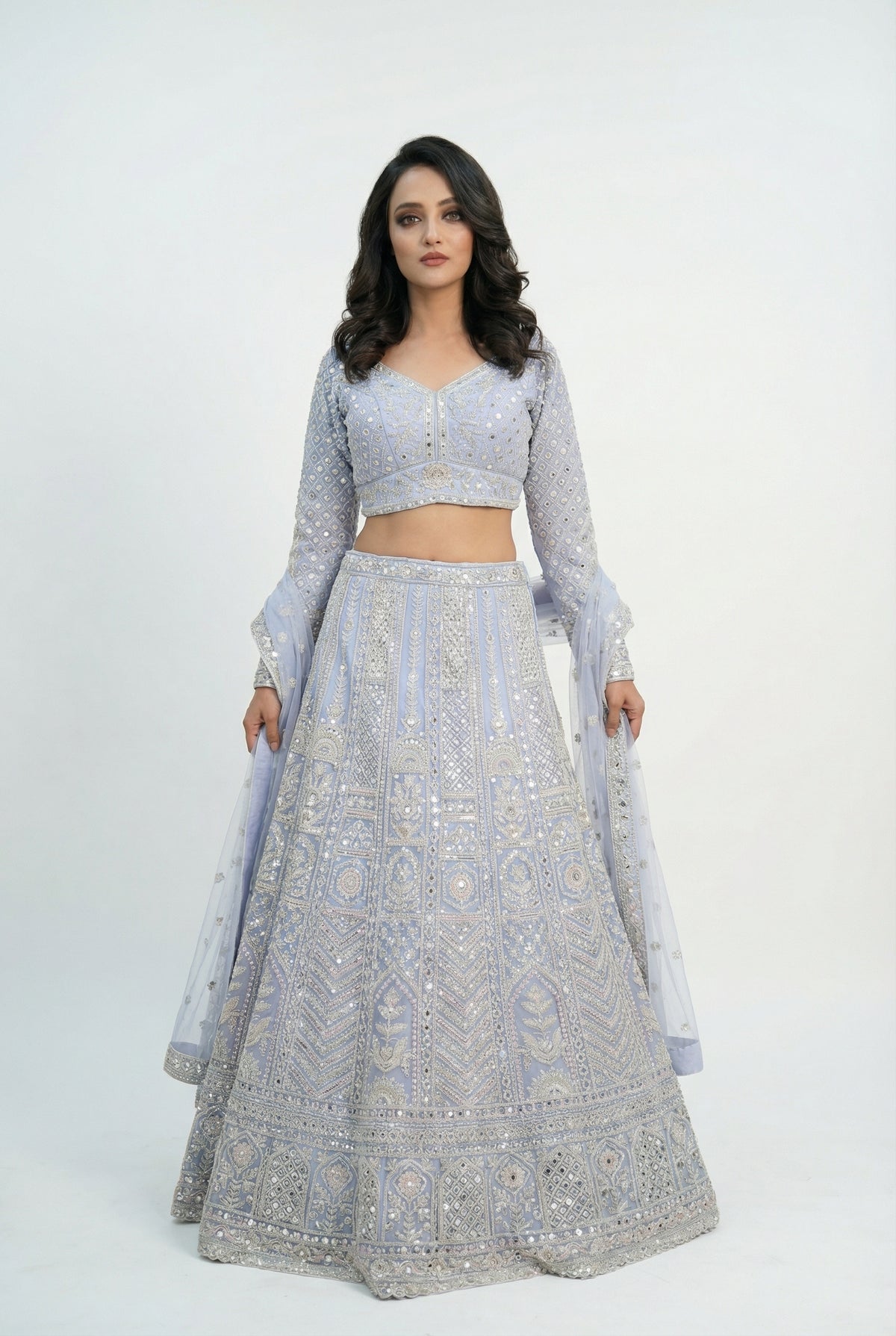 Close-up detail of the intricate geometric and floral patterns created with white beads and sequins on the lavender lehenga skirt.