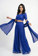 Close-up detail showing the dense, shimmering blue sequin embroidery (sequence work) on the crop top and sharara.