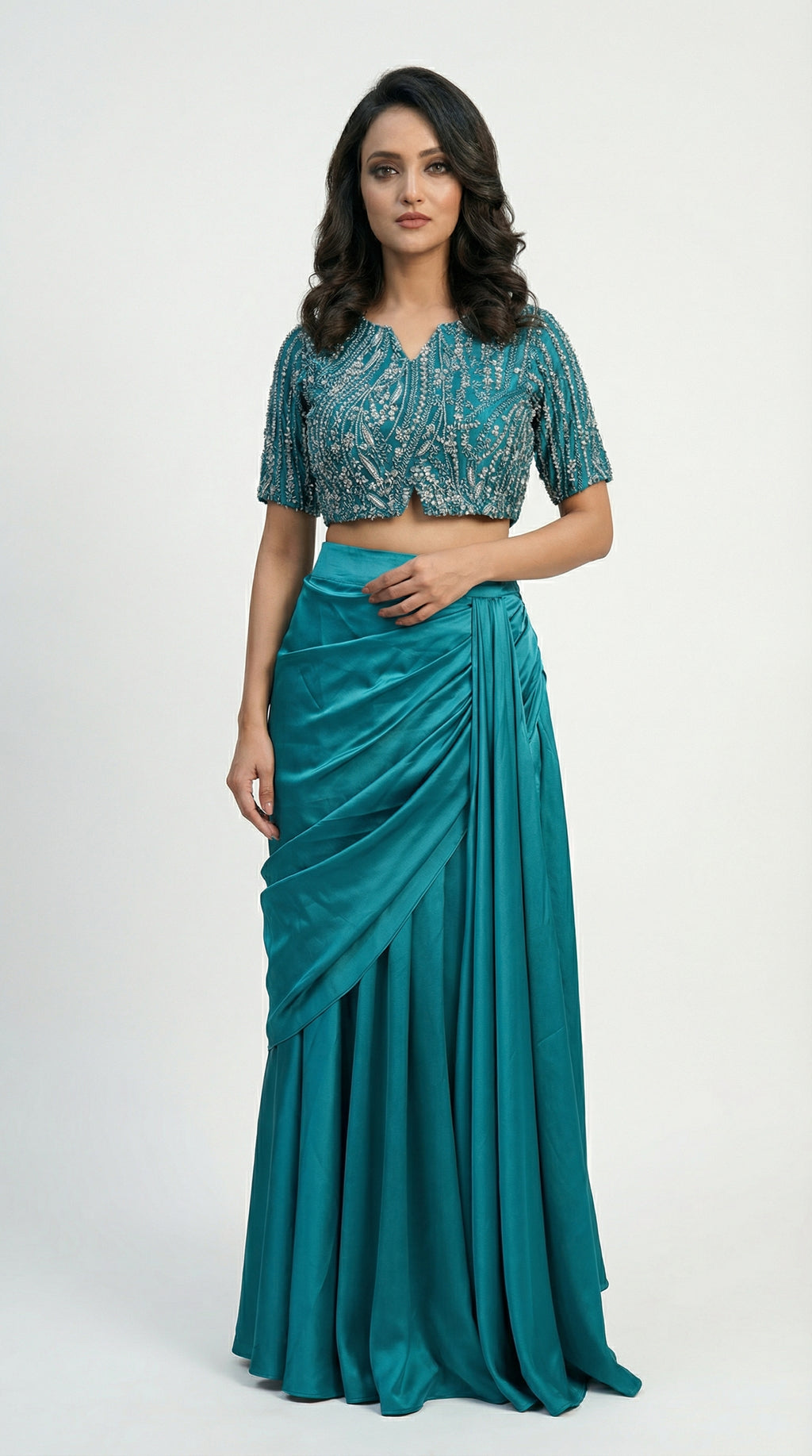 Full body front view of the Rosio House firozi blue indowestern set, featuring a silver cutdana embroidered crop top and Armani satin drape skirt.