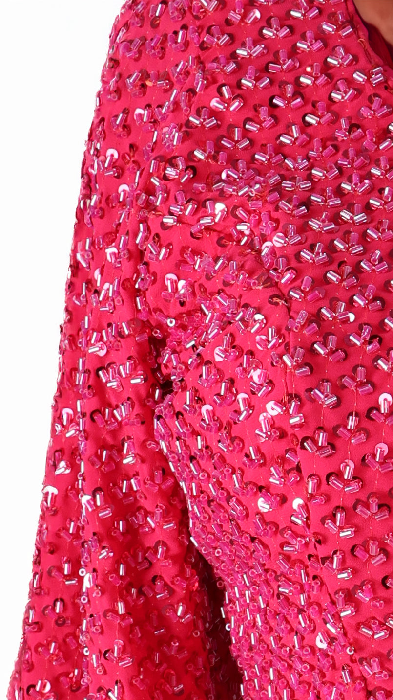 Close-up of a bright pink fabric with a textured pattern on a white background