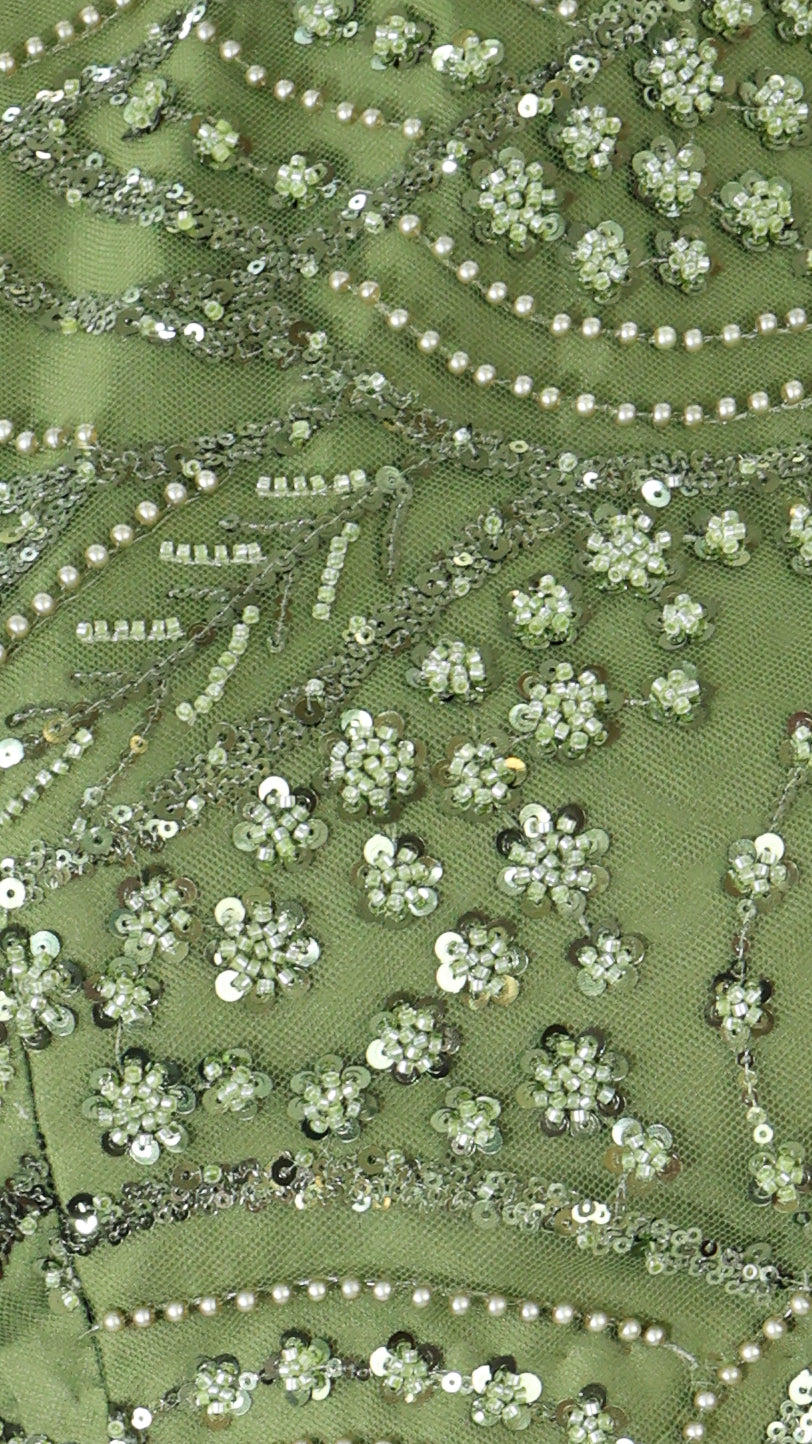 Close-up of green fabric with floral embroidery and sequins