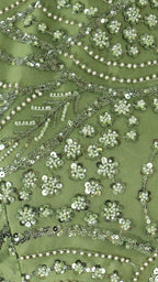 Close-up of green fabric with floral embroidery and sequins