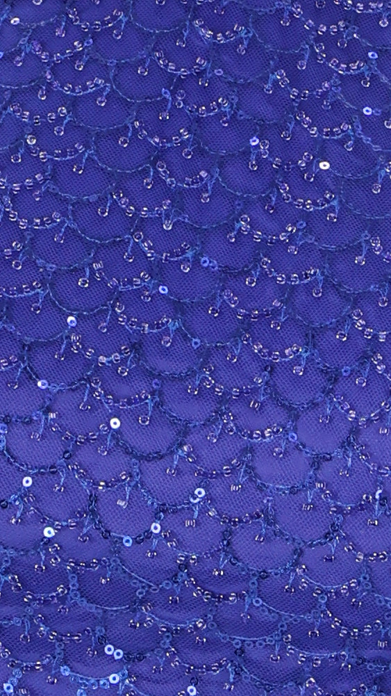 Close-up texture shot showing the dense blue sequins and beads embellished all over the fabric.