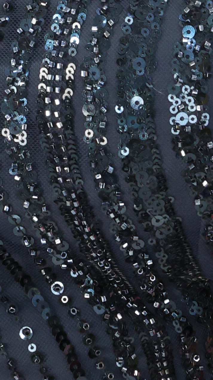 Close-up of sequined fabric with a dark background