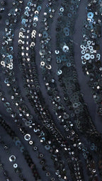 Close-up of sequined fabric with a dark background