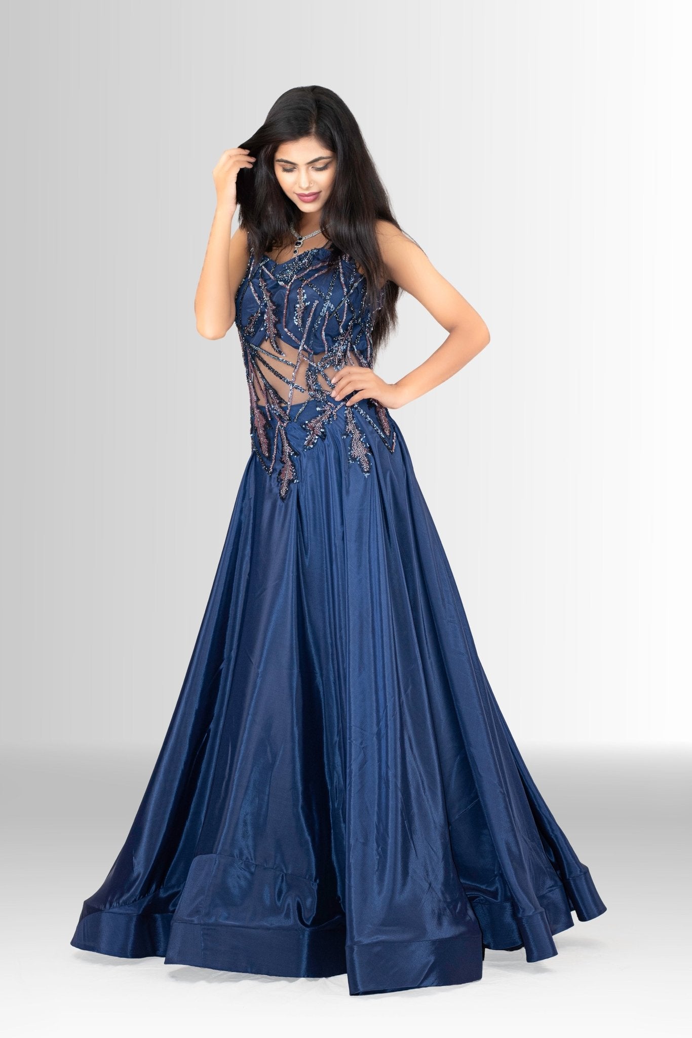 lose-up of the upper bodice of the navy blue gown, showing the detailed sequin and thread embroidery on the sheer net fabric, with a sparkling necklace.
