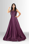 A woman models a full-length, sleeveless plum purple evening gown from Rosio House, featuring a heavily embellished sequin bodice and a flowing A-line satin skirt.