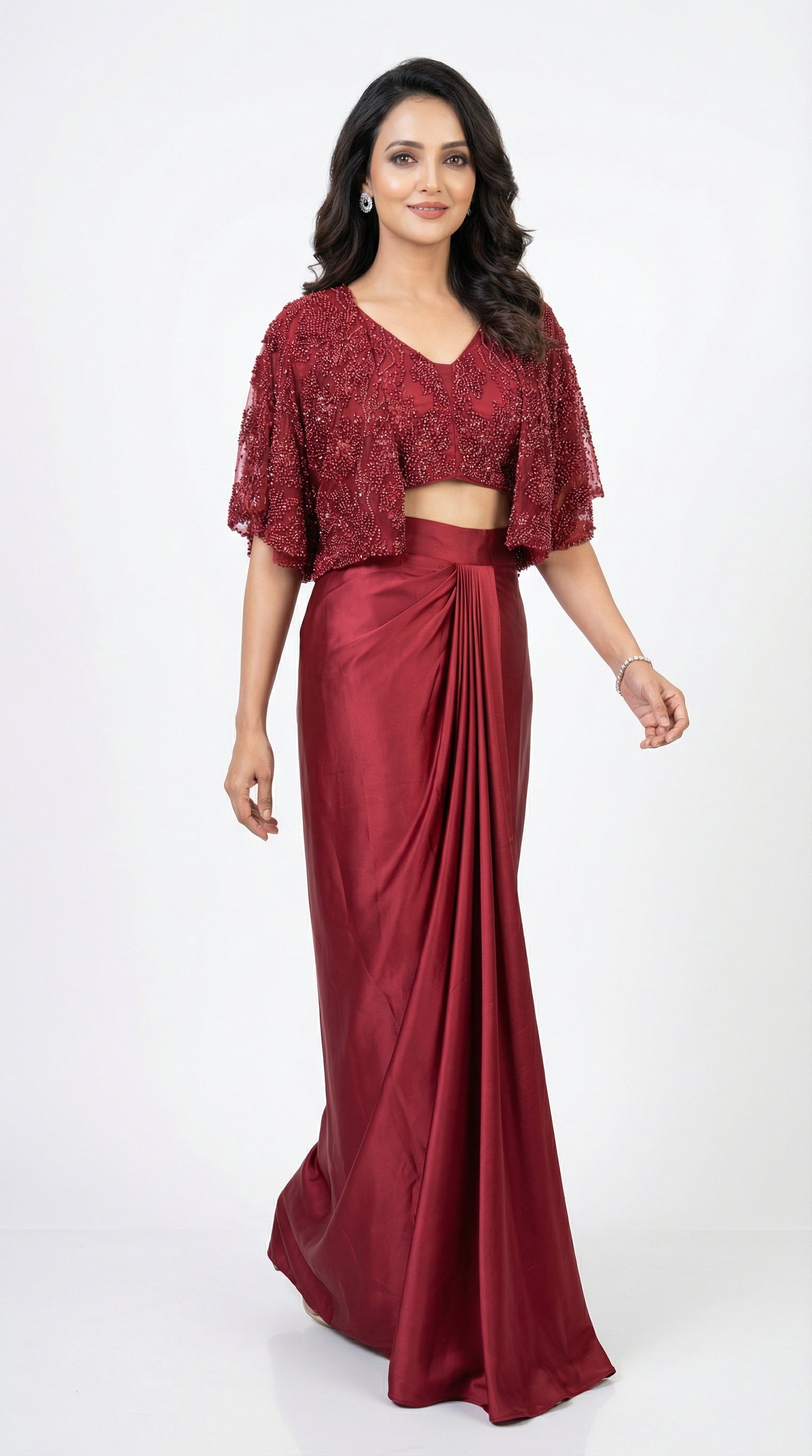 Woman wearing a red saree with a matching blouse on a white background