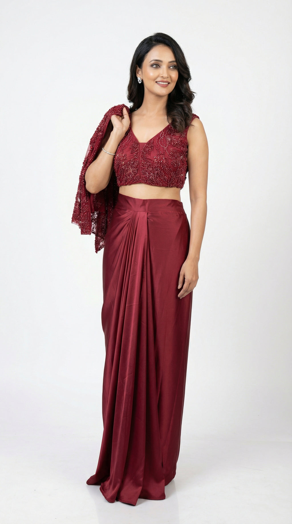 Woman wearing a maroon saree with a matching blouse on a white background
