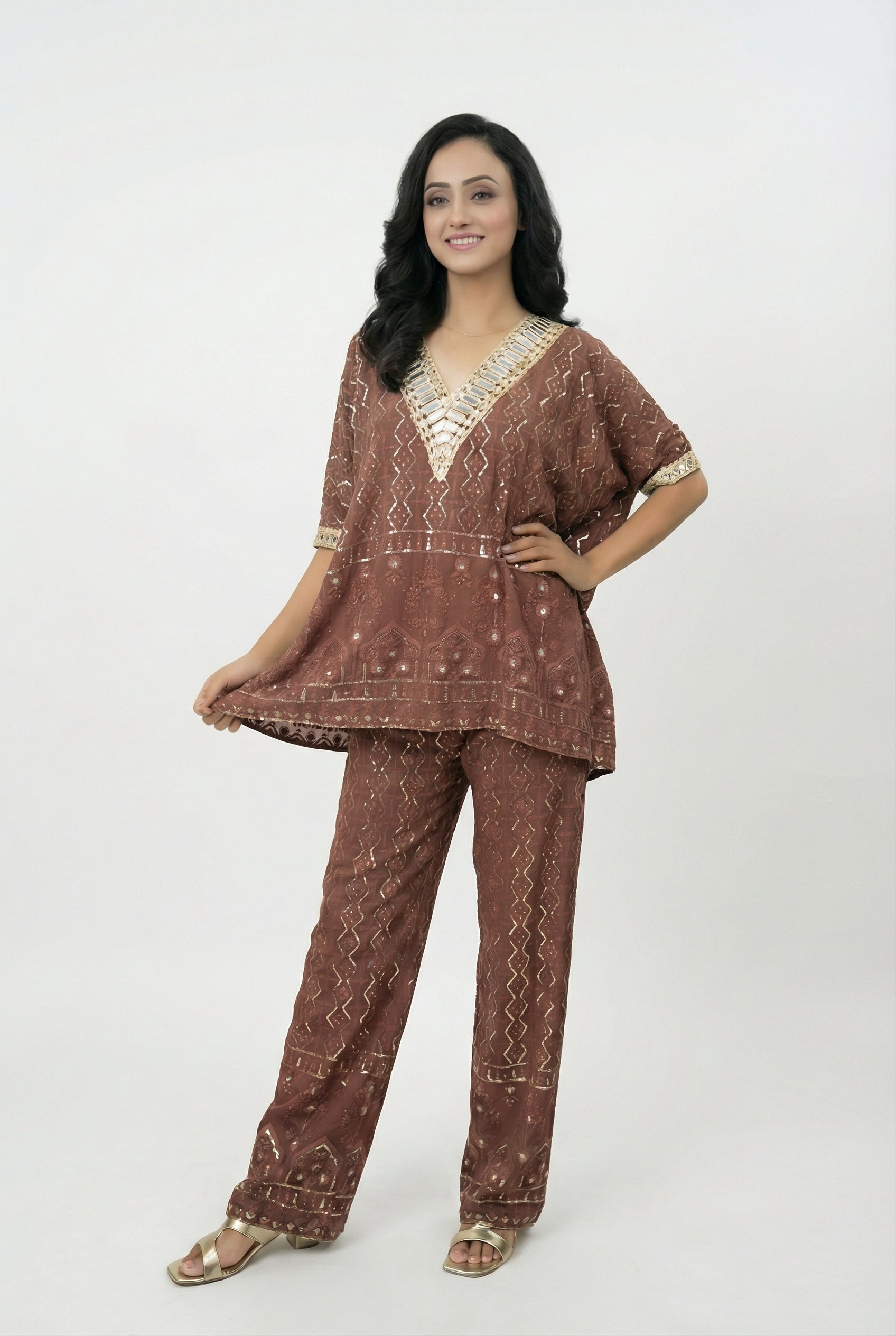 Close-up detail of the heavy silver mirror work (abhla bharat) embroidery on the V-neckline of the rust brown kaftan top.