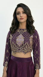 Macro shot of the intricate gold and silver cutdana beadwork in a geometric diamond pattern on the purple blouse.