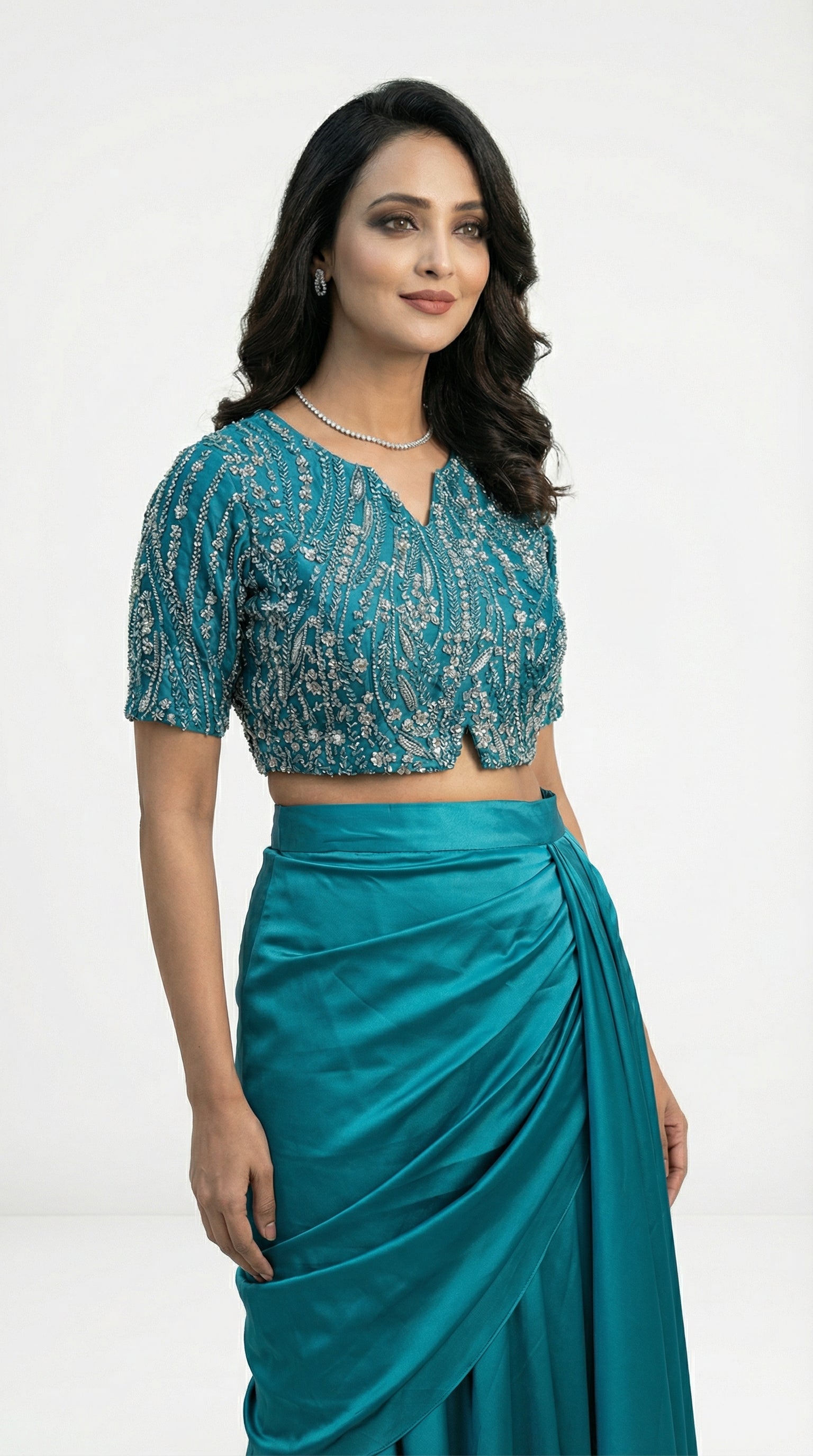 Woman wearing a teal traditional outfit with a white background