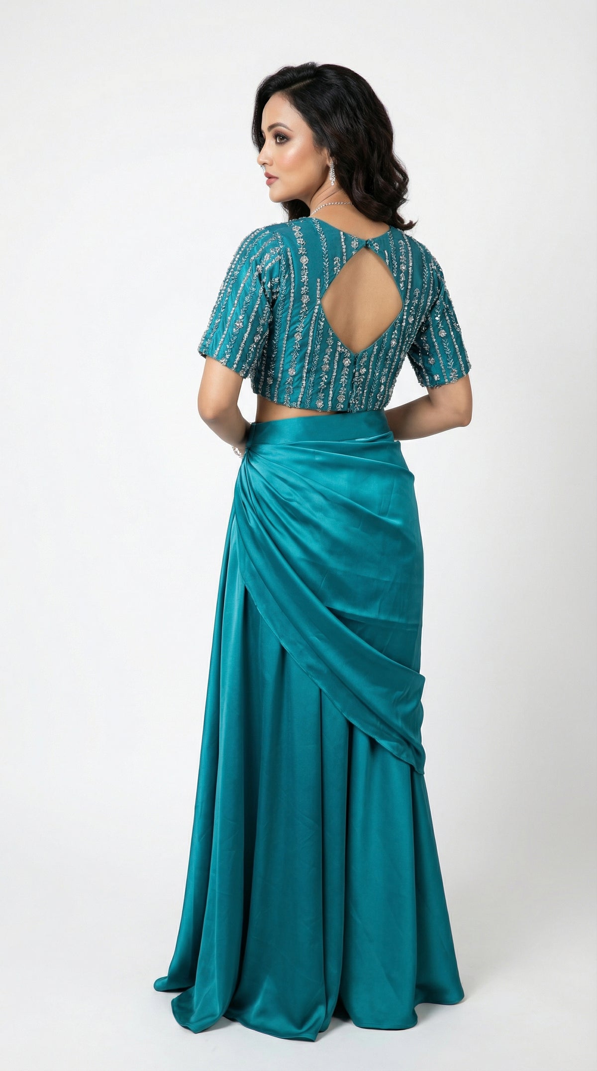 Side profile of the model wearing the firozi drape set, showing the gathered waist detail and the flattering silhouette of the skirt.