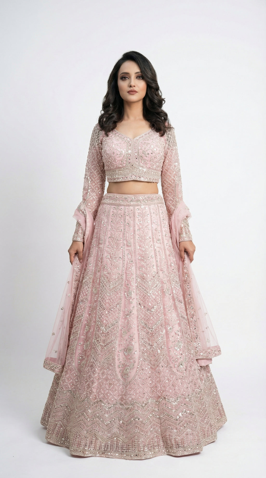 Woman wearing a pink traditional lehenga with a white background