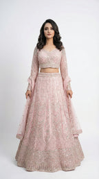 Woman wearing a pink traditional lehenga with a white background