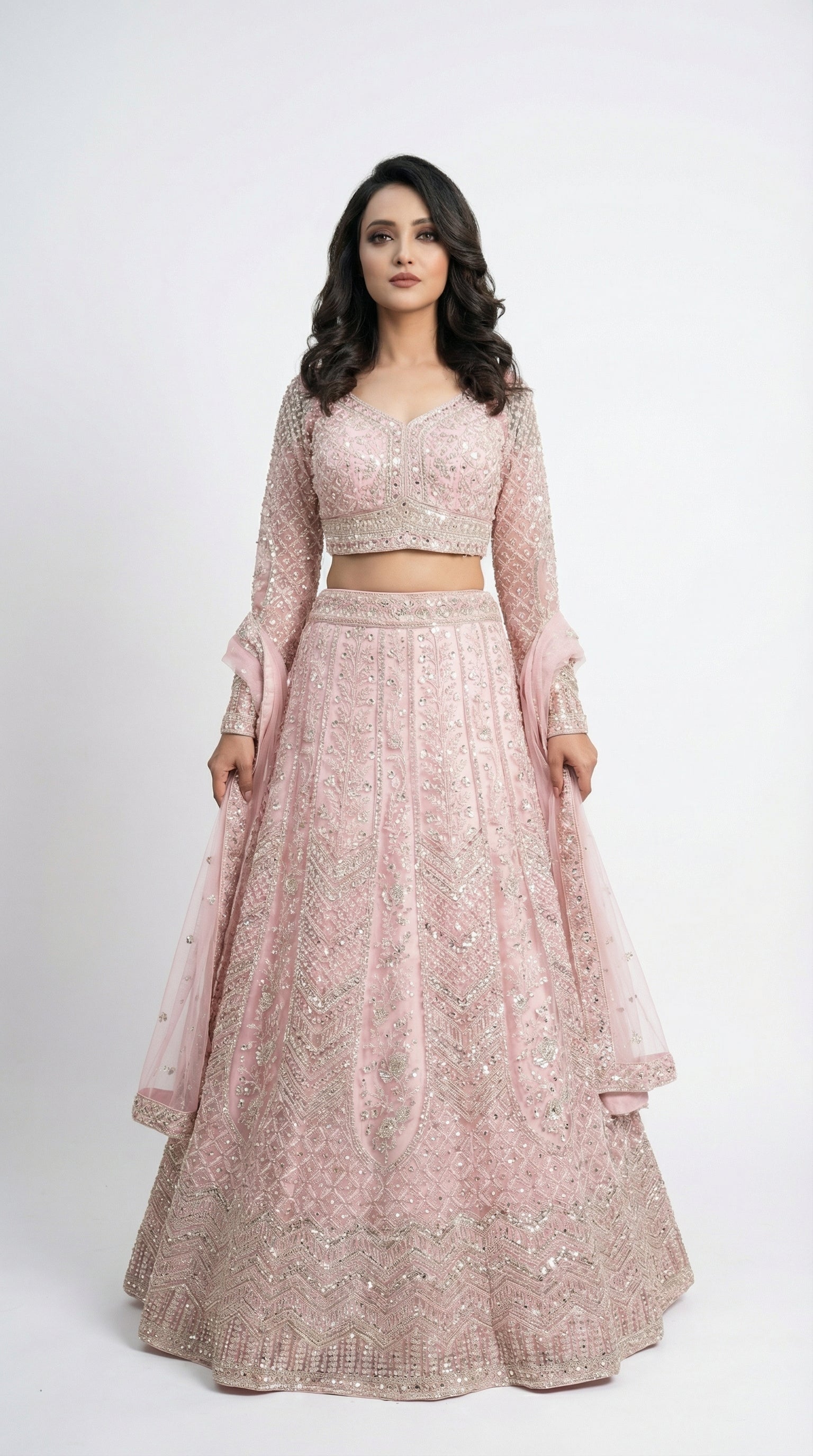 Woman wearing a pink traditional lehenga with a white background