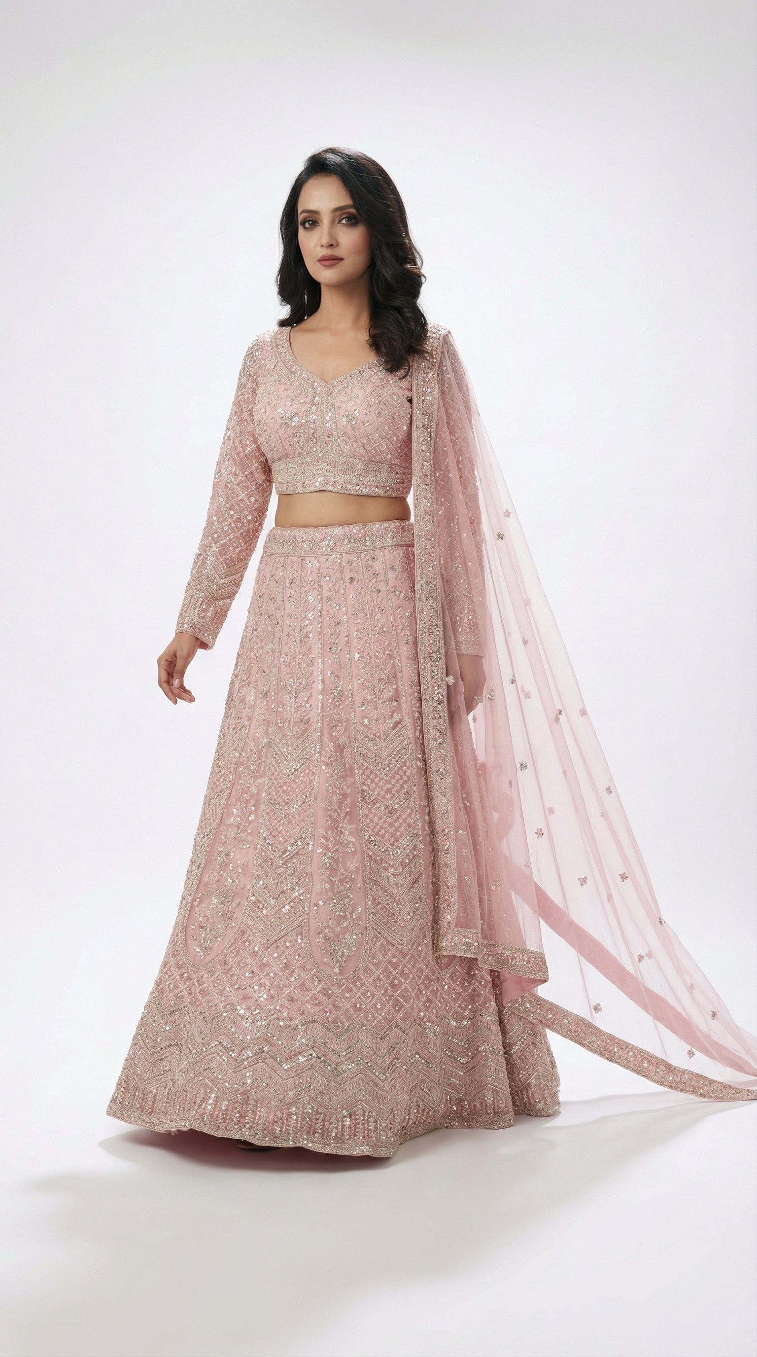 Woman wearing a pink traditional lehenga with a white background