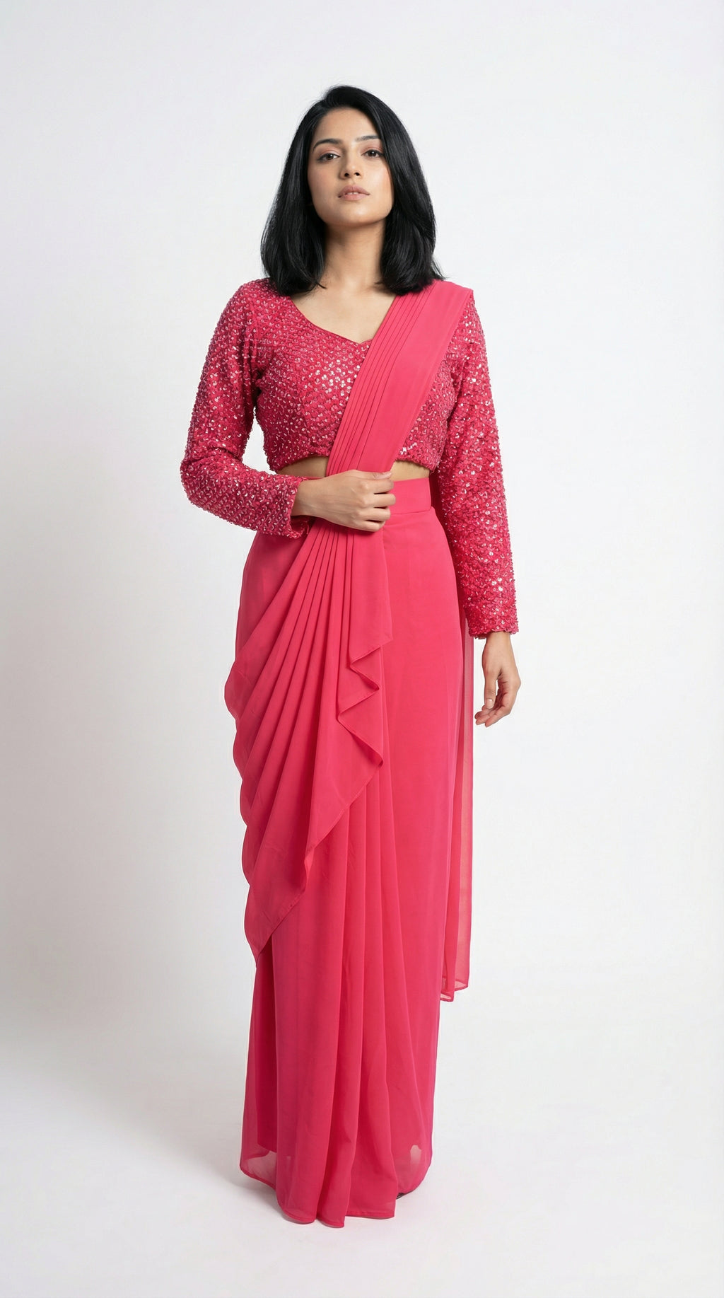Woman wearing a pink saree with a matching blouse on a white background