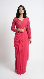 Woman wearing a pink saree with a matching blouse on a white background