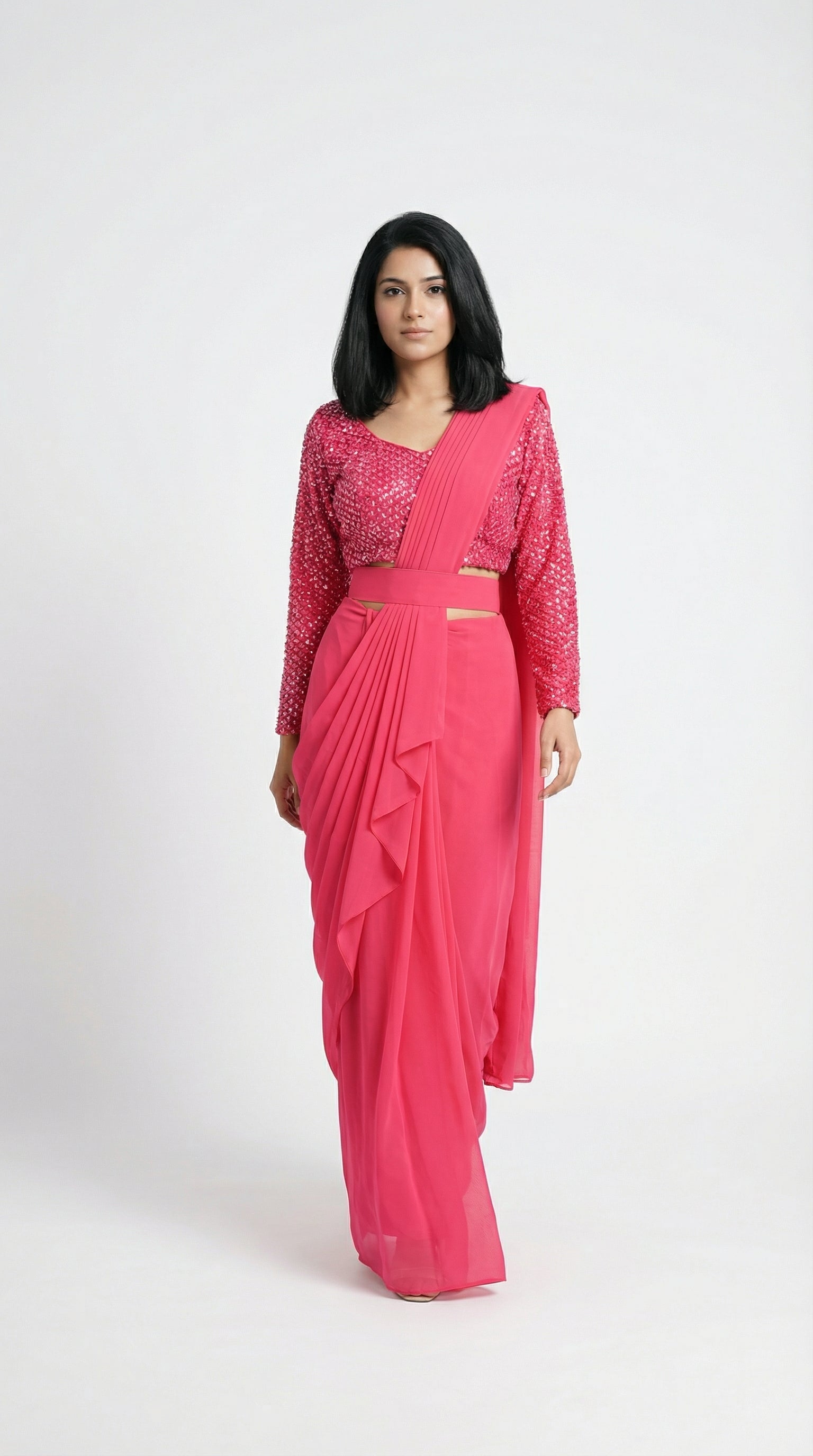 Woman wearing a pink saree with a matching blouse on a white background