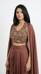 Woman wearing a brown indowestern outfit with a cape