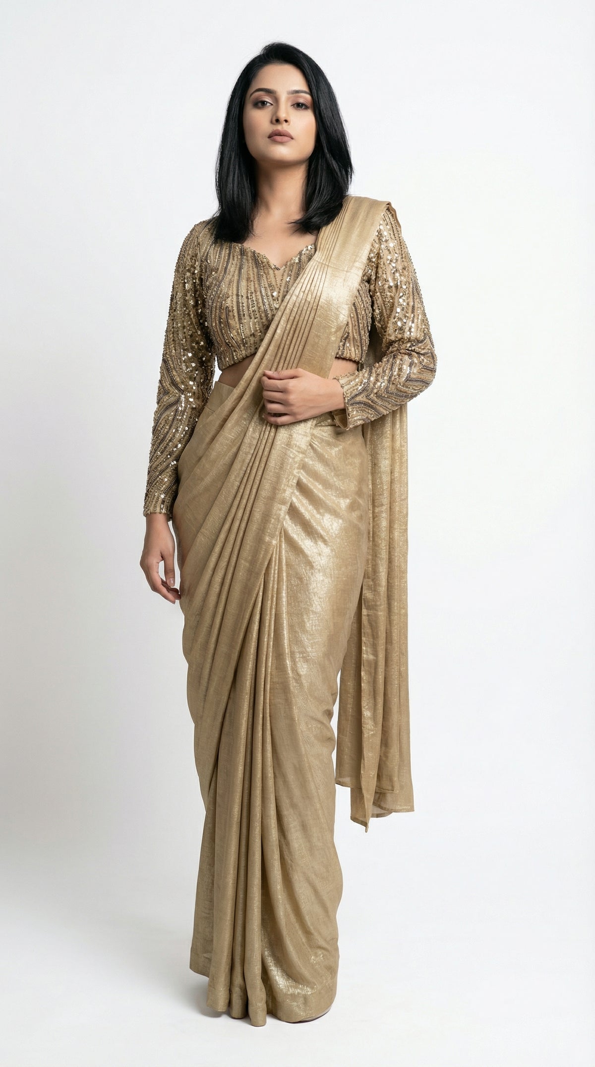 Woman wearing a gold saree with a matching blouse on a white background
