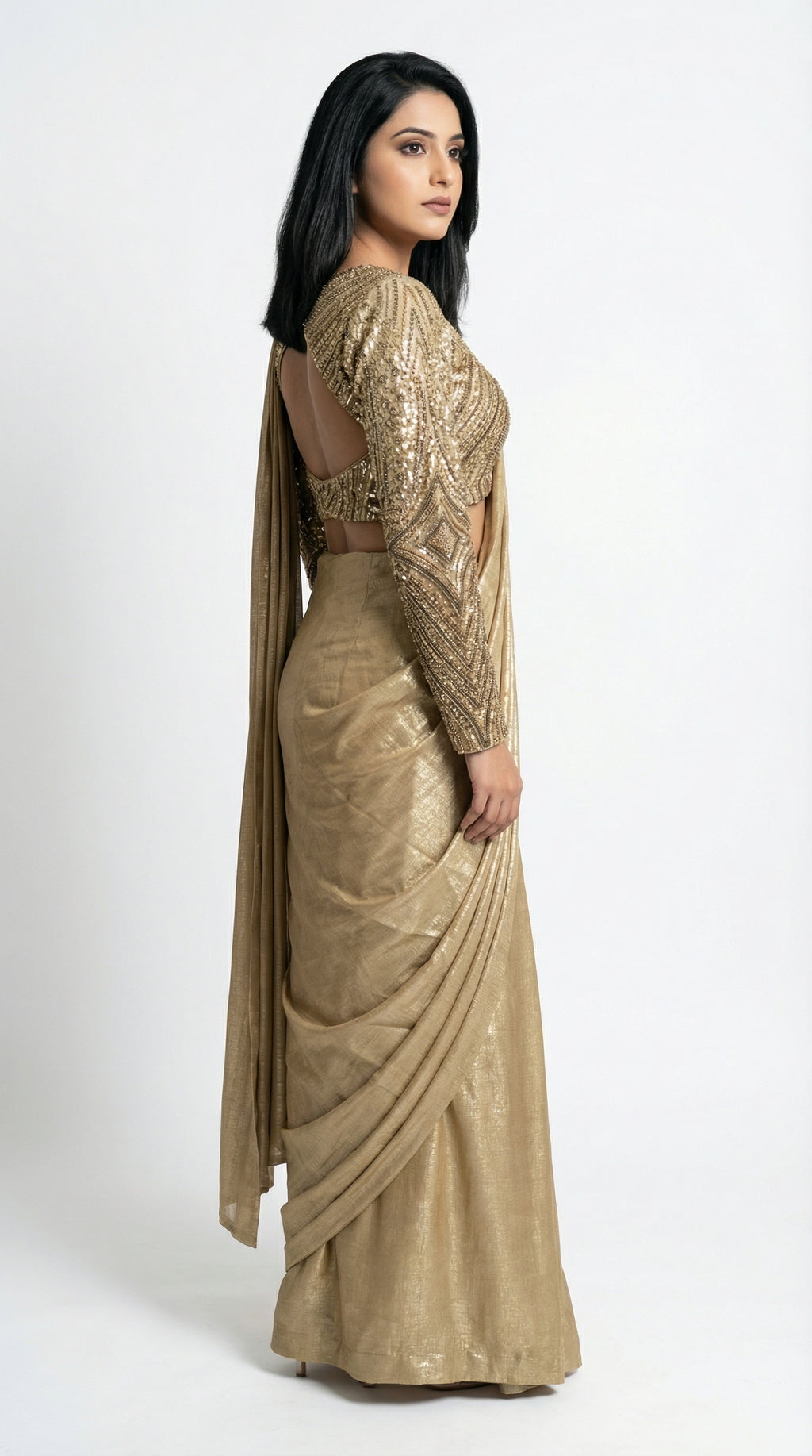 Woman wearing a gold saree with a plain background