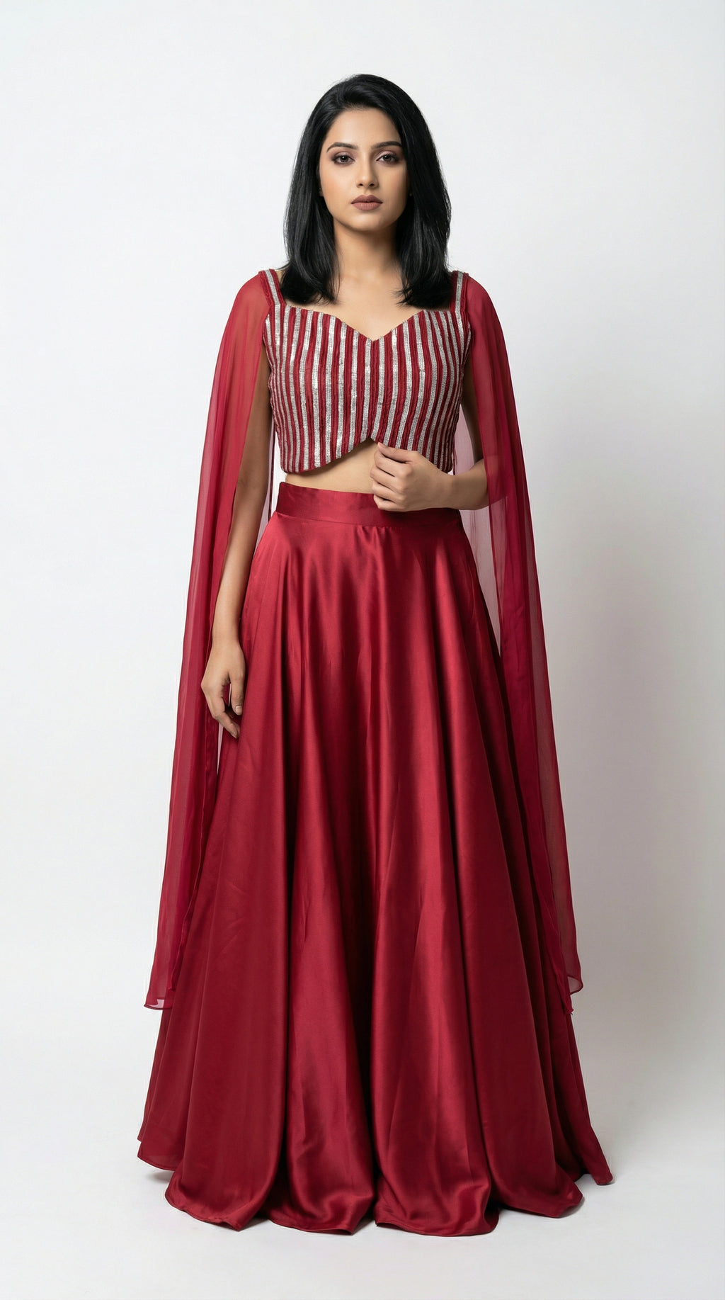 Woman wearing a red crop top handwork and flowy skirt with a white background