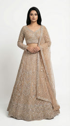 Woman wearing a beige embroidered lehenga for wedding, engagement and parties