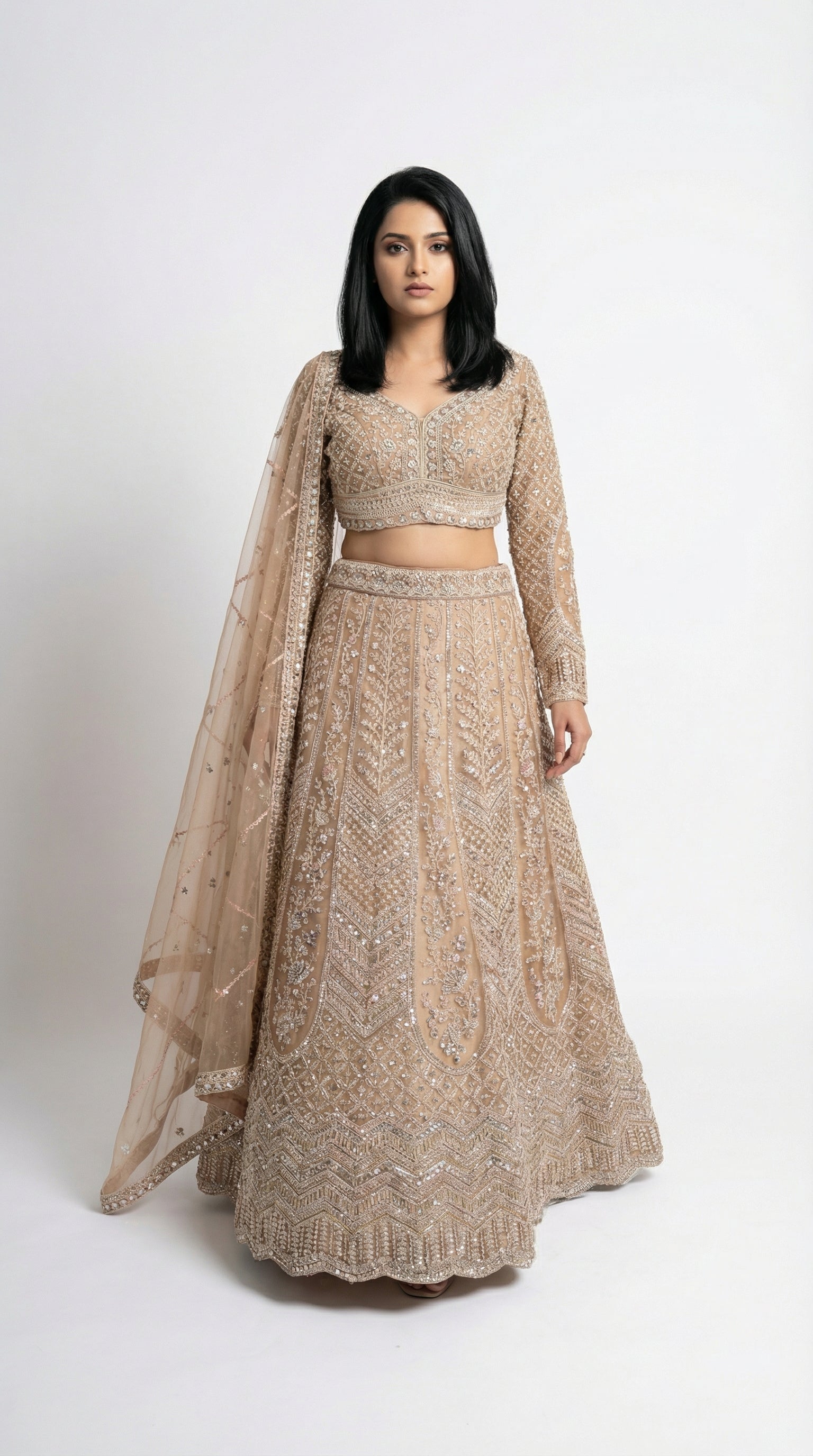 Woman wearing a beige embroidered lehenga for wedding, engagement and parties