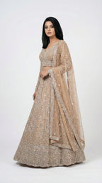 Woman wearing a beige embroidered lehenga for wedding, engagement and parties