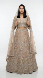 Woman wearing a beaded lehenga with a matching dupatta on a white background