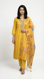 Woman wearing a yellow traditional outfit with floral dupatta on a white background