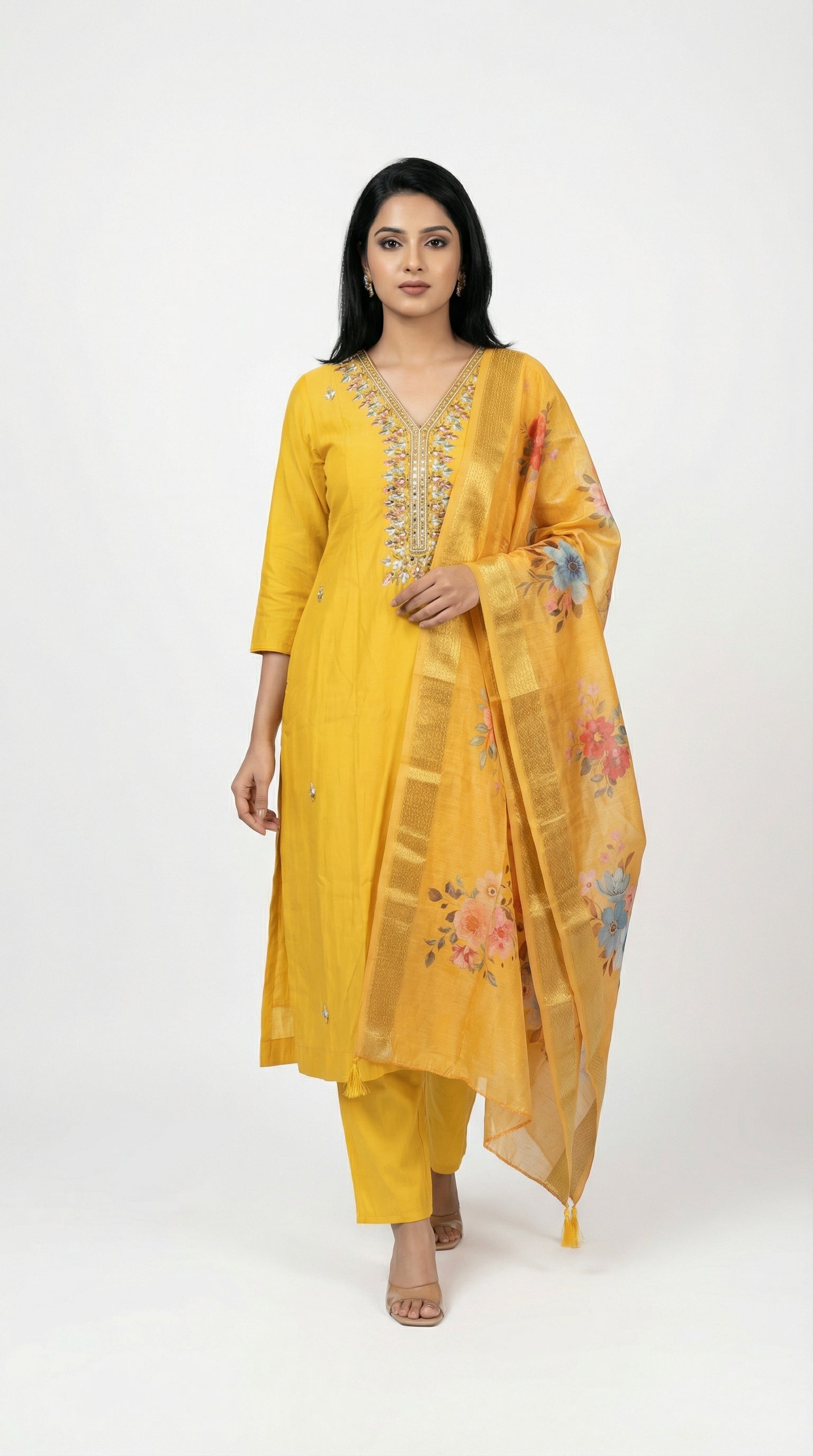 Woman wearing a yellow traditional outfit with a floral dupatta on a white background