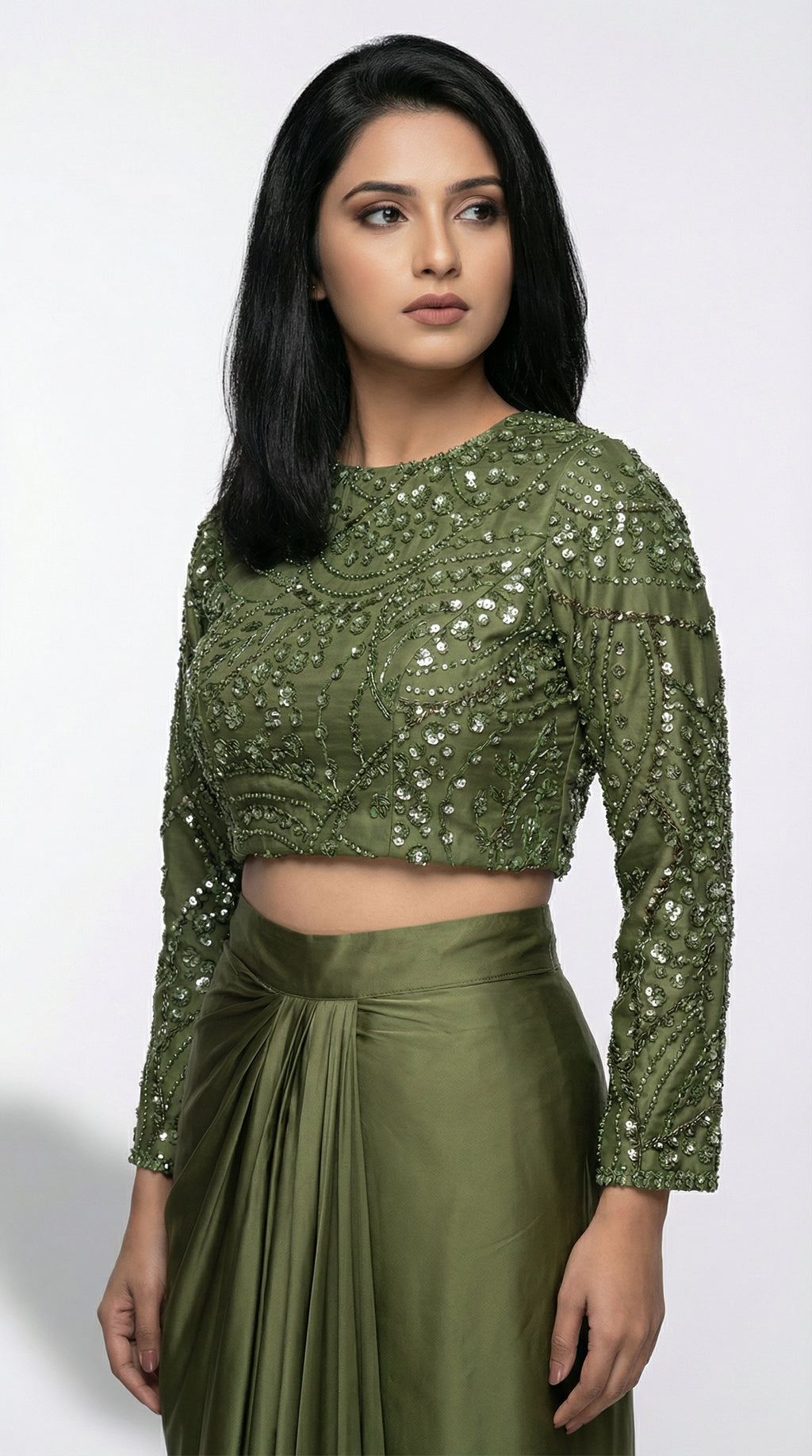 Woman wearing a green sequined top and skirt on a white background