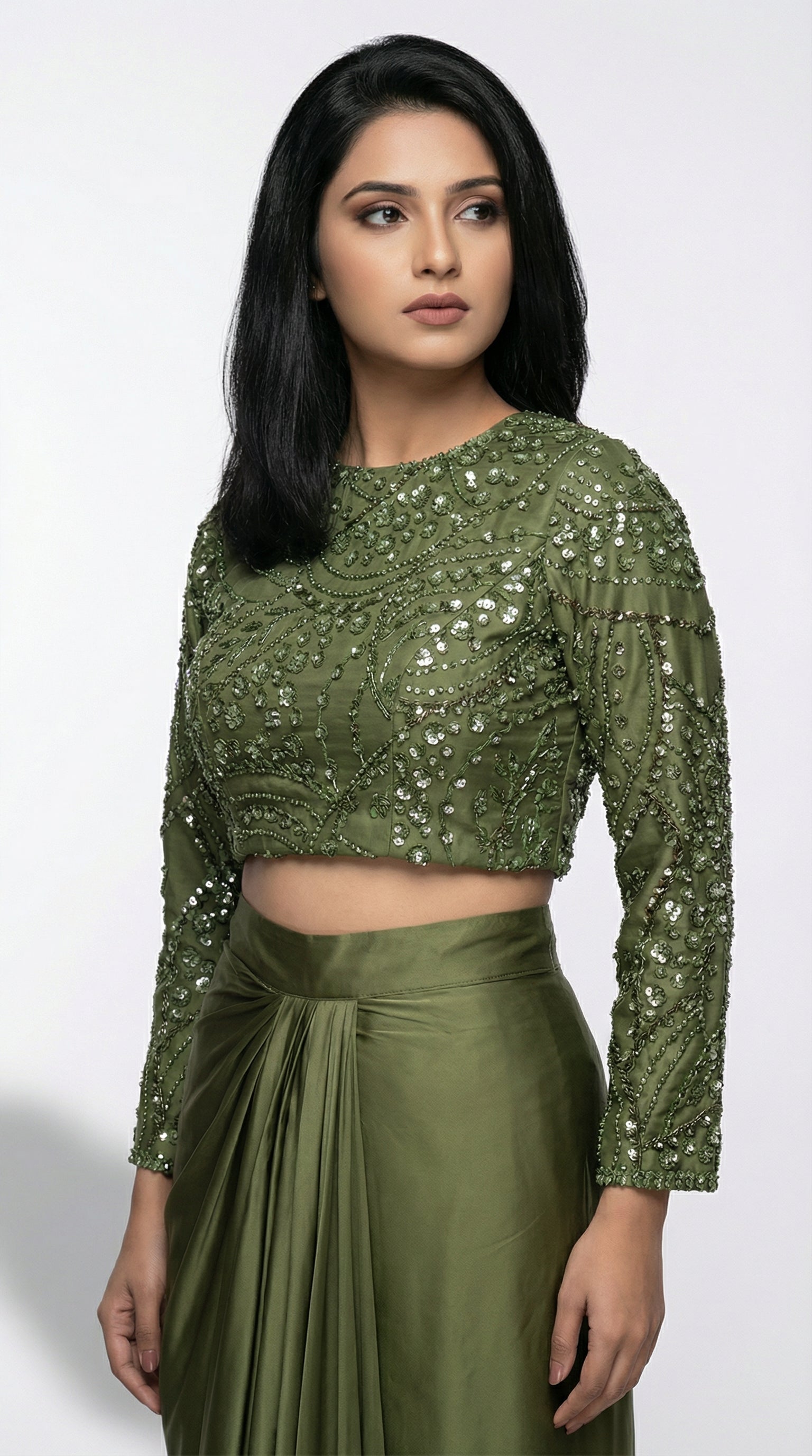 Woman wearing a green sequined top and skirt on a white background