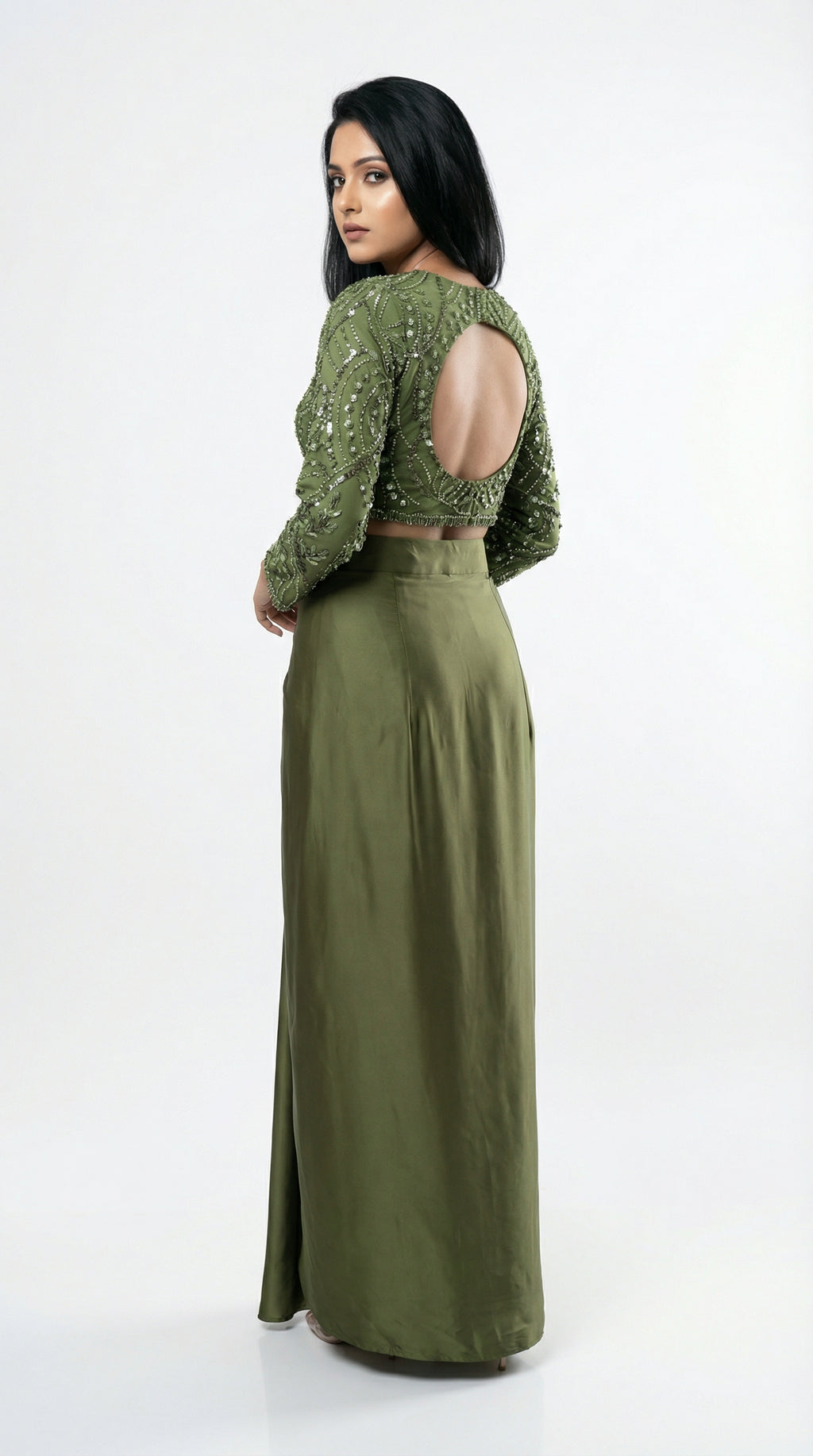 Woman wearing a green outfit with open back on a white background