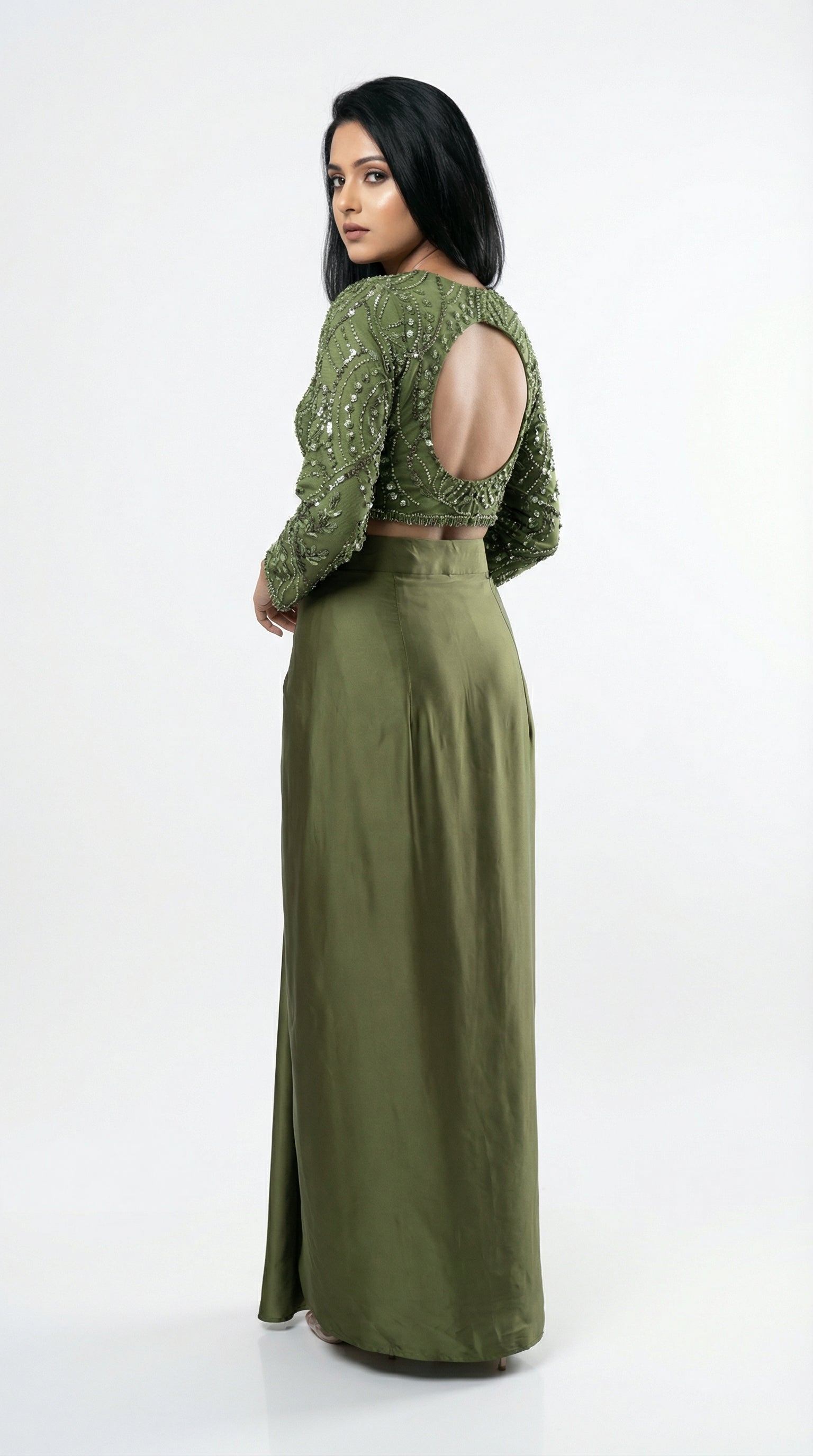 Woman wearing a green outfit with open back on a white background
