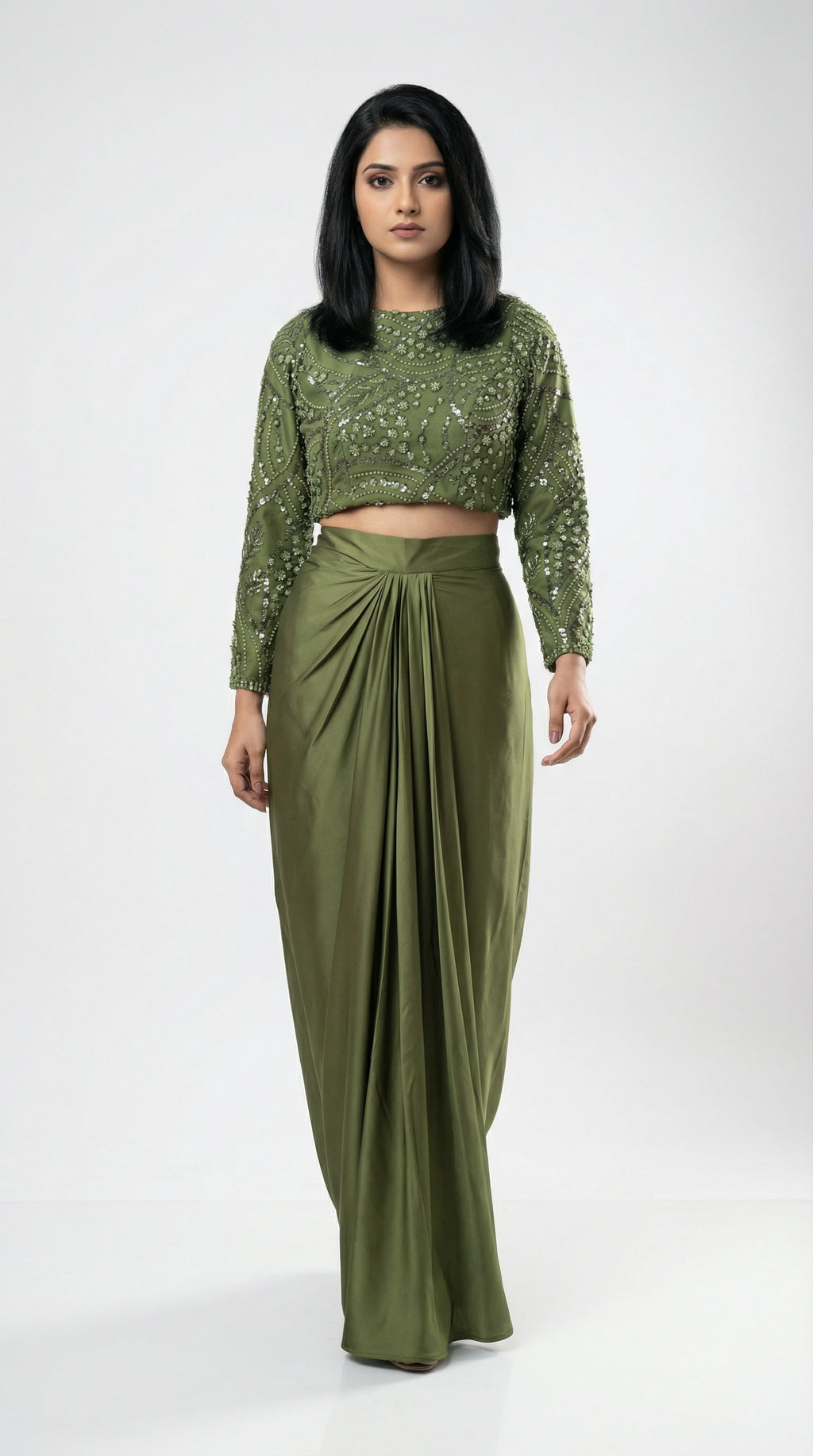 Woman wearing a green outfit with a top and long skirt on a white background