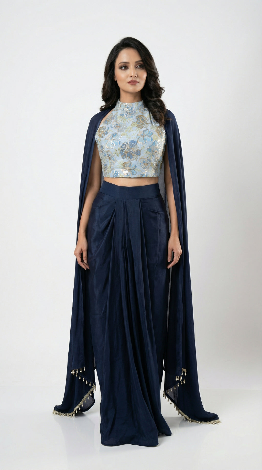 A view of the long sheer navy blue shrug, highlighting the delicate tassel details on the hemline.