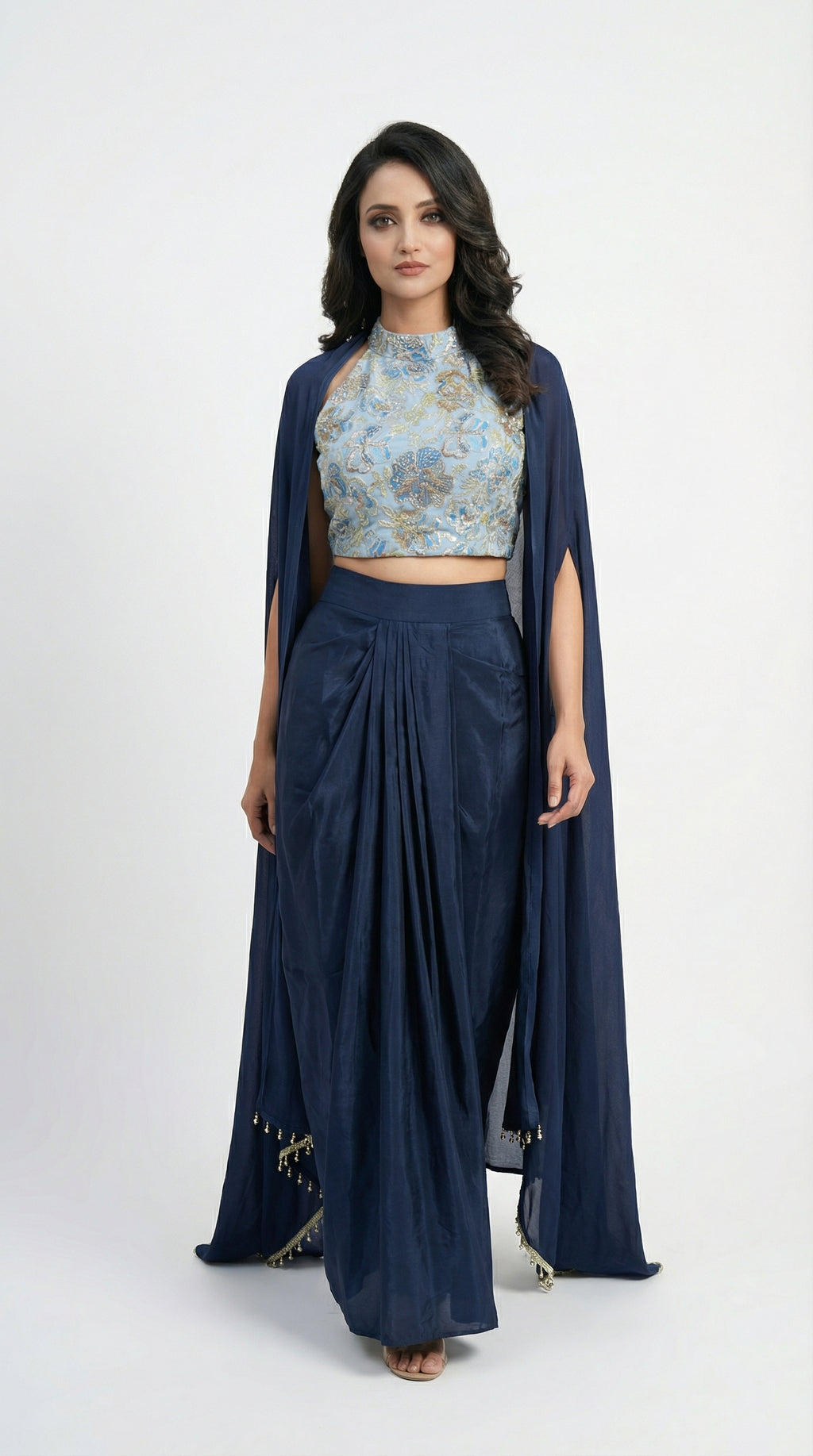 Full body front view of the Rosio House navy blue indowestern set featuring a floral sequin halter top, satin drape skirt, and long shrug.