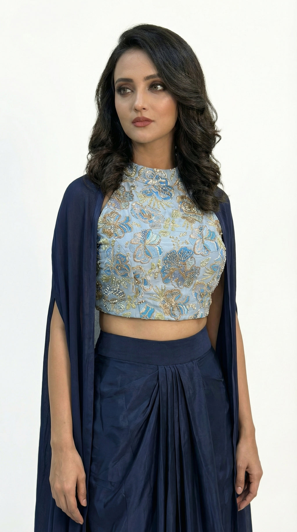 Close-up detail of the light blue halter neck crop top showing the intricate floral print and sequin work.