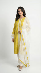 A view of the white straight pants with hem buttons and the sheer white dupatta with scattered motifs and yellow border.