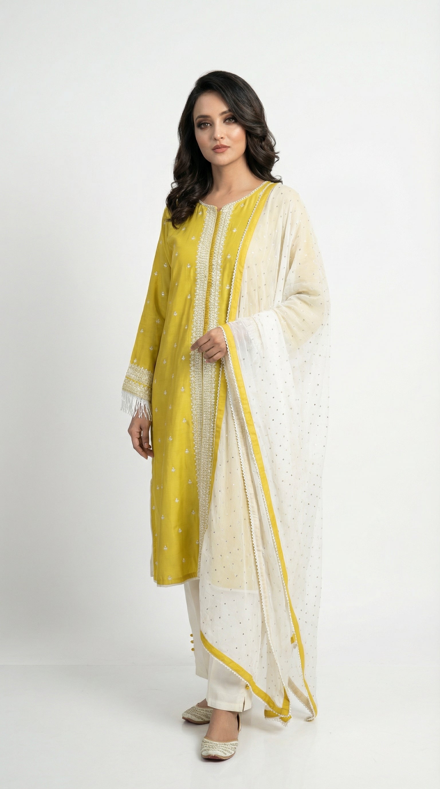A view of the white straight pants with hem buttons and the sheer white dupatta with scattered motifs and yellow border.