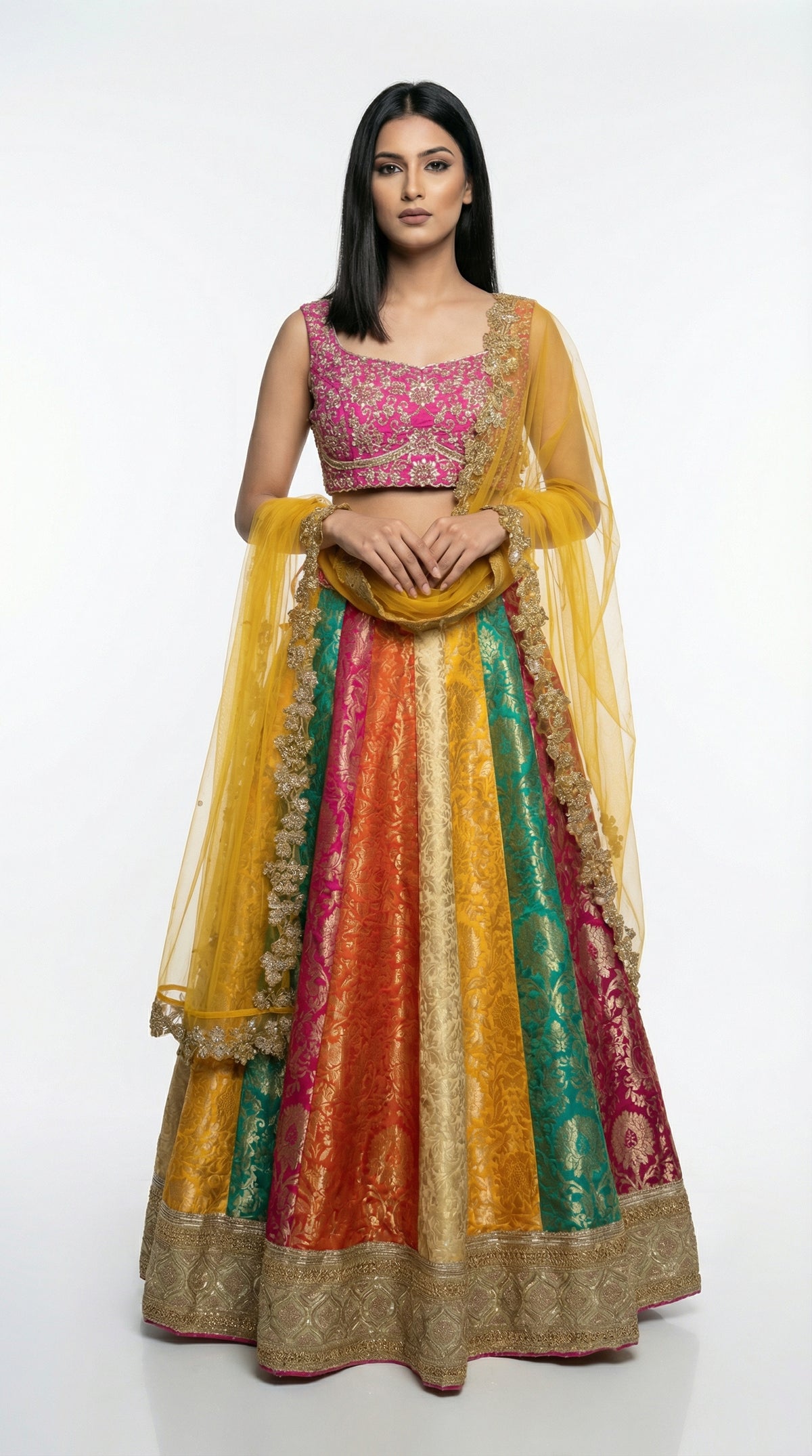 Detail shot of the hot pink sleeveless blouse featuring dense gold embroidery, paired with the multicolor skirt.