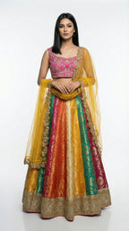 Detail shot of the hot pink sleeveless blouse featuring dense gold embroidery, paired with the multicolor skirt.