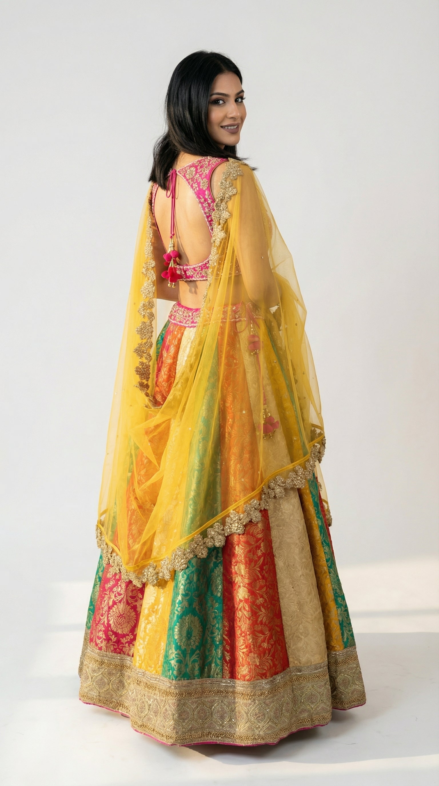 A view of the yellow net dupatta draped over the arm, highlighting the heavy gold scalloped cutwork border.