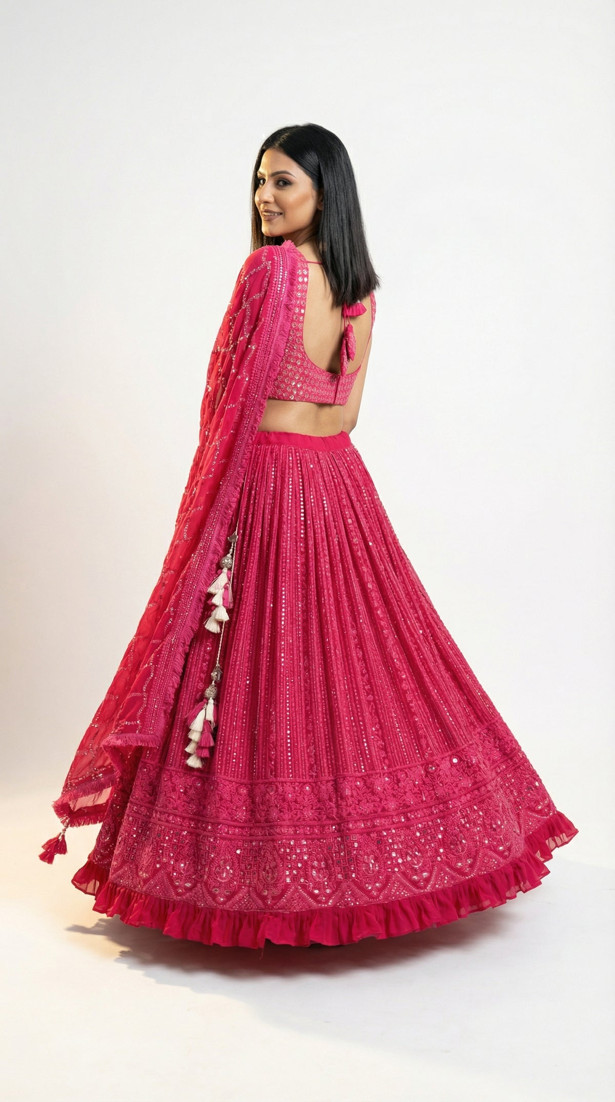 Detail shot of the matching sleeveless pink blouse adorned with heavy mirror work and thread embroidery.