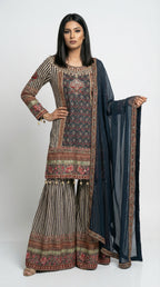 Close-up detail of the hemline of the navy blue kurta, highlighting the intricate floral border print and hanging gold bead tassels.