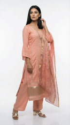 Detail shot showing the wide gold tissue border at the hemline of the peach kurta.